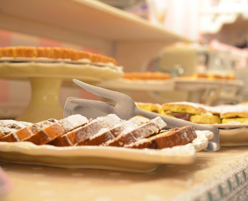 Fette di torta su piatti, spolverate di zucchero a velo, in un buffet.