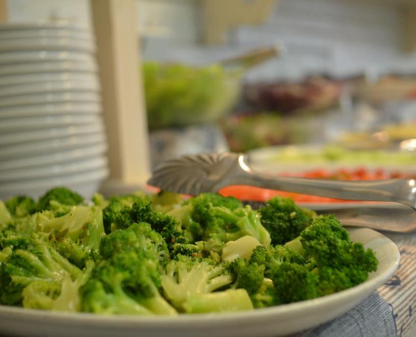 Piatto di broccoli su tavolo da buffet con pinze.